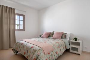 a white bedroom with a bed and a window at Los Alisios del Patron in Playa Honda