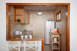 a kitchen with a table and a white refrigerator at Los Alisios del Patron in Playa Honda