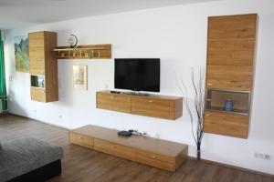ein Wohnzimmer mit einem Flachbildfernseher an der Wand in der Unterkunft Apartment am Römerkreis in Heidelberg