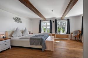a bedroom with a bed and two windows at Knutzenswarft - Deichgraf in Westerhever