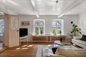 a living room with a couch and a tv at Knutzenswarft - Deichgraf in Westerhever