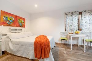 a bedroom with a bed with an orange blanket on it at El Lagar in Los Silos