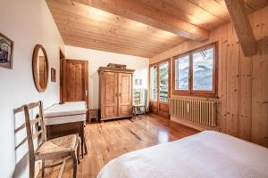 a bedroom with a bed and a desk and a window at Chalet Franclair in Samoëns