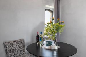 a table with bottles of wine and flowers on it at Suite Fattoressa in San Gimignano