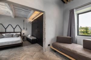 a bedroom with a bed and a large window at Suite Fattoressa in San Gimignano