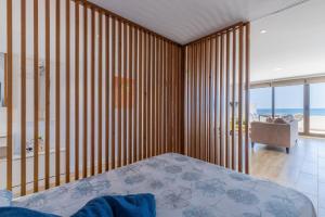 a bedroom with wooden walls and a bed and a balcony at Top first line apartment Altea in Altea