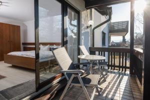 a room with a balcony with a bed and a table and chairs at Gästehaus Noller in Bodman-Ludwigshafen