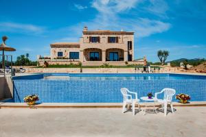 a house with a pool and two chairs and a table at Can Vadell in Calonge