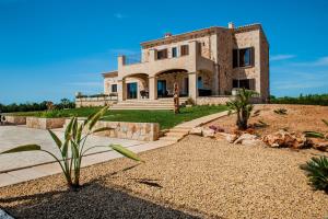 a large stone house with a landscaping at Can Vadell in Calonge