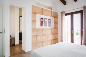 a bedroom with white walls and a brick wall at Can Vadell in Calonge +37 photos