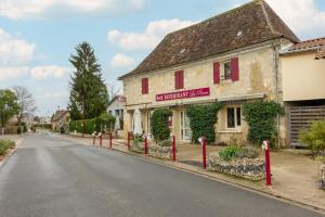 a street in front of a building with red posts at Appartement La Pierre in Saint-Médard-de-Mussidan