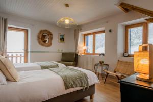 a bedroom with two beds and a couch and windows at La Colline aux Rêves - Chambres d'hôtes in Saint-Franc