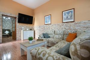 a living room with a couch and a tv on a brick wall at Casa Dayaday in Puerto del Rosario