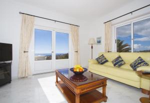 a living room with a yellow couch and a table at Casa Mcelroy in Tías