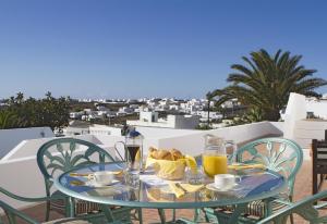 a glass table with food and drinks on a balcony at Casa Mcelroy in Tías