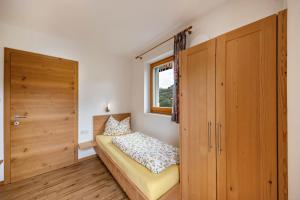 a small bedroom with a bed and a window at Tschafon Oberparnaihof in Collepietra