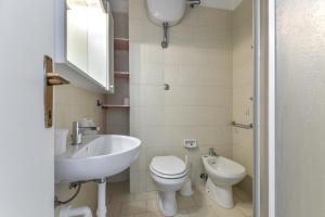 a white bathroom with a sink and a toilet at Il Quadrifoglio 3 in Procchio +15 photos