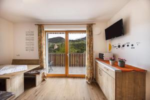 a room with a bed and a sliding glass door at Tschafon Oberparnaihof in Collepietra