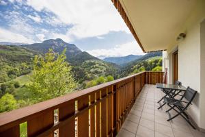 a balcony with a table and chairs and mountains at Tschafon Oberparnaihof in Collepietra
