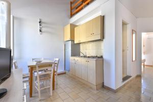 a kitchen with a table and a dining room at Il Quadrifoglio 3 in Procchio