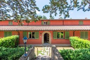 an orange house with green shutters and a street light at Villa Pesca in Trequanda