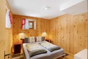 a bedroom with a bed in a room with wooden walls at Tea da Anna e Luigi in Livigno