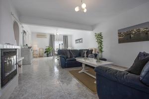 a living room with blue couches and a fireplace at Villa Casa Rosina in Ferragudo