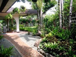 a garden with a pavilion and some plants and trees at Casa Joaquin BnB in Manila
