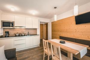 a kitchen and dining room with a table and chairs at Chalet La Flüta Primula in La Valle +17 photos