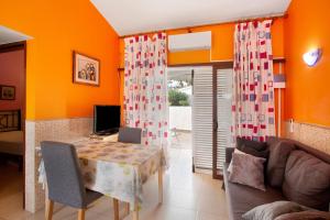 a living room with orange walls and a table and a couch at Haus Brigitte in Playa del Ingles