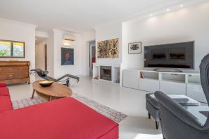a living room with a red couch and a tv at Casa Sunny in Port de Soller