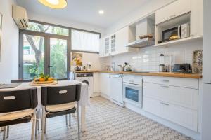 a kitchen with white cabinets and a table and chairs at Casa Sunny in Port de Soller