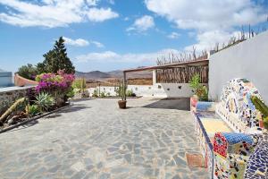 a patio with a bench and flowers and a building at Finca Fani 2 in Agüimes