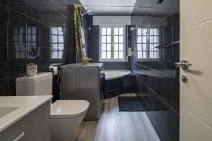 a bathroom with a toilet and a tub and a sink at Casita Do Muelle - Cambados in Cambados +14 photos