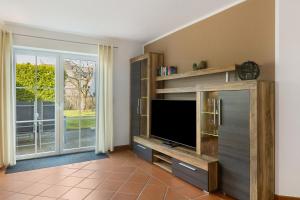 a living room with a tv and a sliding glass door at Ferienwohnung Dora in Medebach