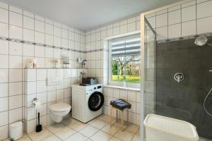 a bathroom with a washing machine and a shower at Ferienwohnung Dora in Medebach +14 photos