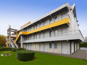 an apartment building with a balcony and a lawn at Premiere Classe Blois Nord in Blois