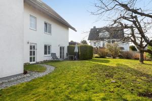 a garden of a white house with a lawn at Ferienwohnung Dora in Medebach
