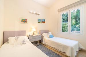 a bedroom with two beds and a window at Villa Armonia in Pyrgi