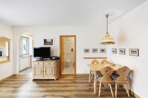 a dining room with a table and chairs and a television at Fewo Brünnstein - Nr 44 Pool, Sauna in Oberaudorf