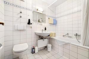 a white bathroom with a toilet and a sink at Fewo Brünnstein - Nr 44 Pool, Sauna in Oberaudorf +12 photos