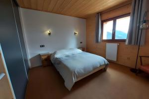 a bedroom with a bed in a room with a window at Morzine Panoramic in Morzine
