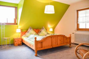 a bedroom with a wooden bed with a green wall at Ferienwohnung Moog in Steinach