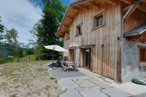 a patio with a table and an umbrella next to a building at Morzine Panoramic in Morzine
