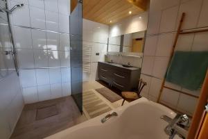 a bathroom with a shower and a sink and a tub at Morzine Panoramic in Morzine +11 photos