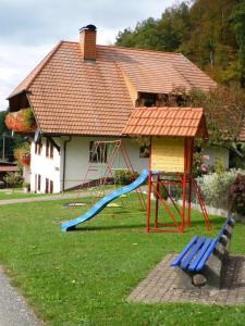 a playground with a slide and a house at Ferienwohnung Moog in Steinach