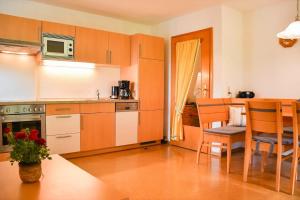 a kitchen with orange cabinets and a table and chairs at Ferienwohnung Moog in Steinach