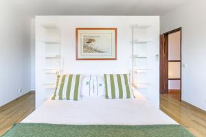 a bedroom with white walls and a bed with striped pillows at Herdade da Tamanqueira in Pomar +27 photos