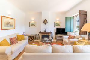a living room with white couches and a fireplace at Herdade da Tamanqueira in Pomar