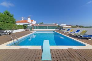 a swimming pool with lounge chairs on a wooden deck at Herdade da Tamanqueira in Pomar